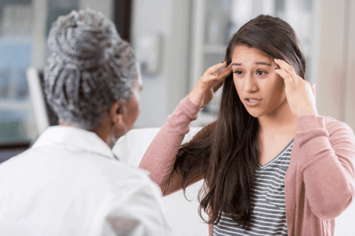 A teenager talking to a doctor about depressive symptoms