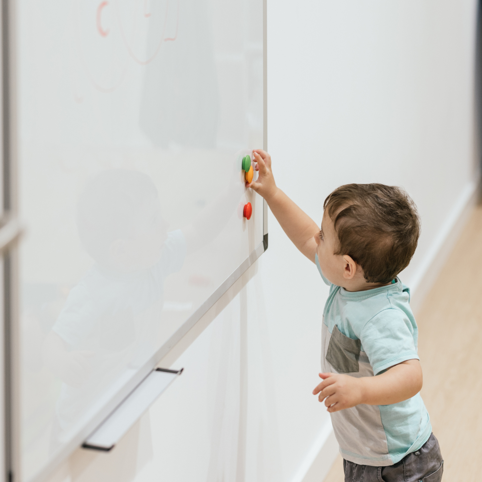 A small child playing with a white board