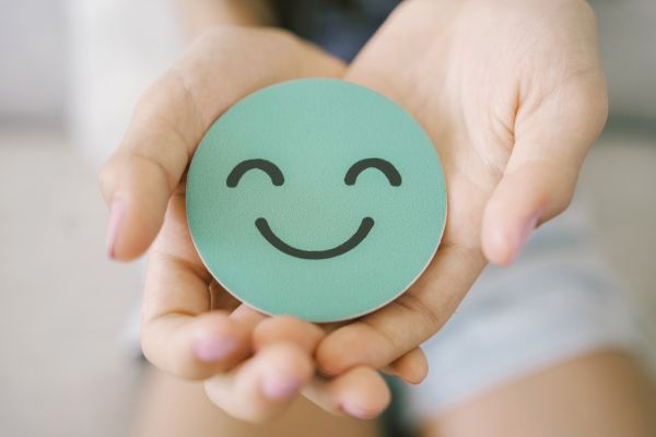 A smiling face badge in a childs hands